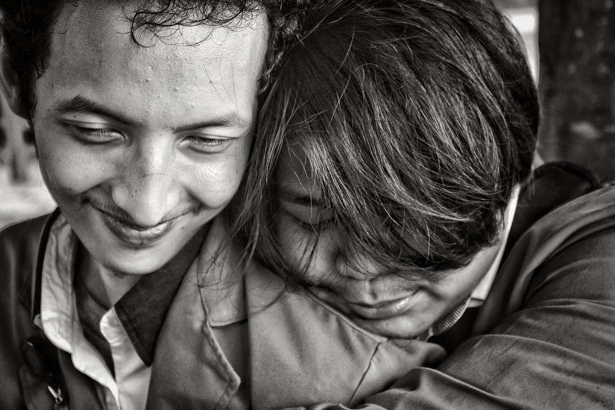 people greyscale photo of two people close to each other human