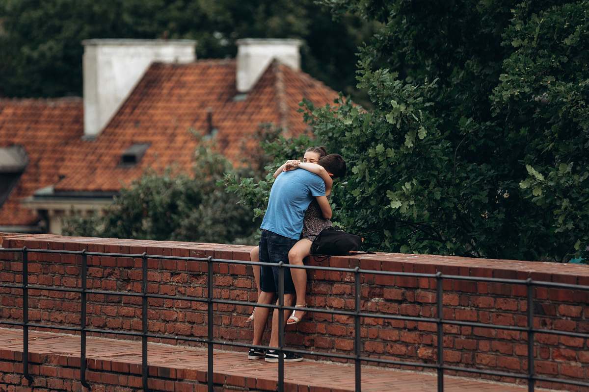 shorts man and woman sitting on wall apparel