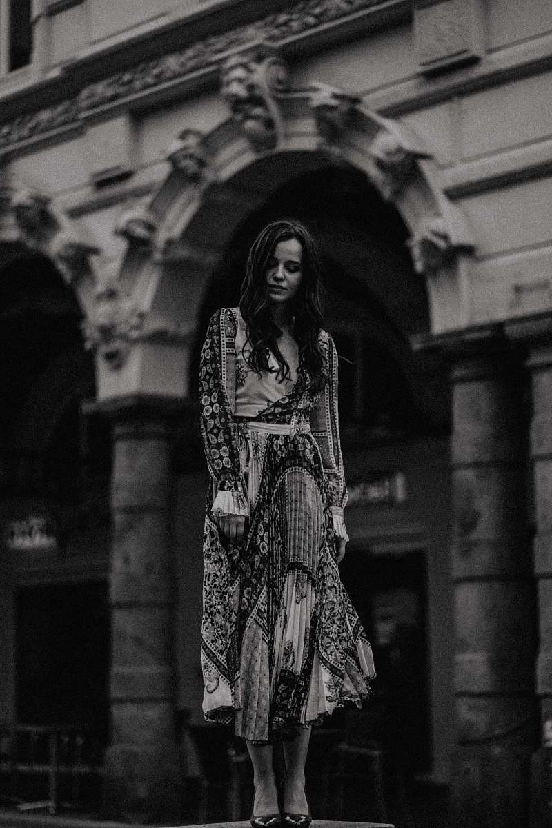 apparel woman wearing black and white maxi dress near white building black-and-white