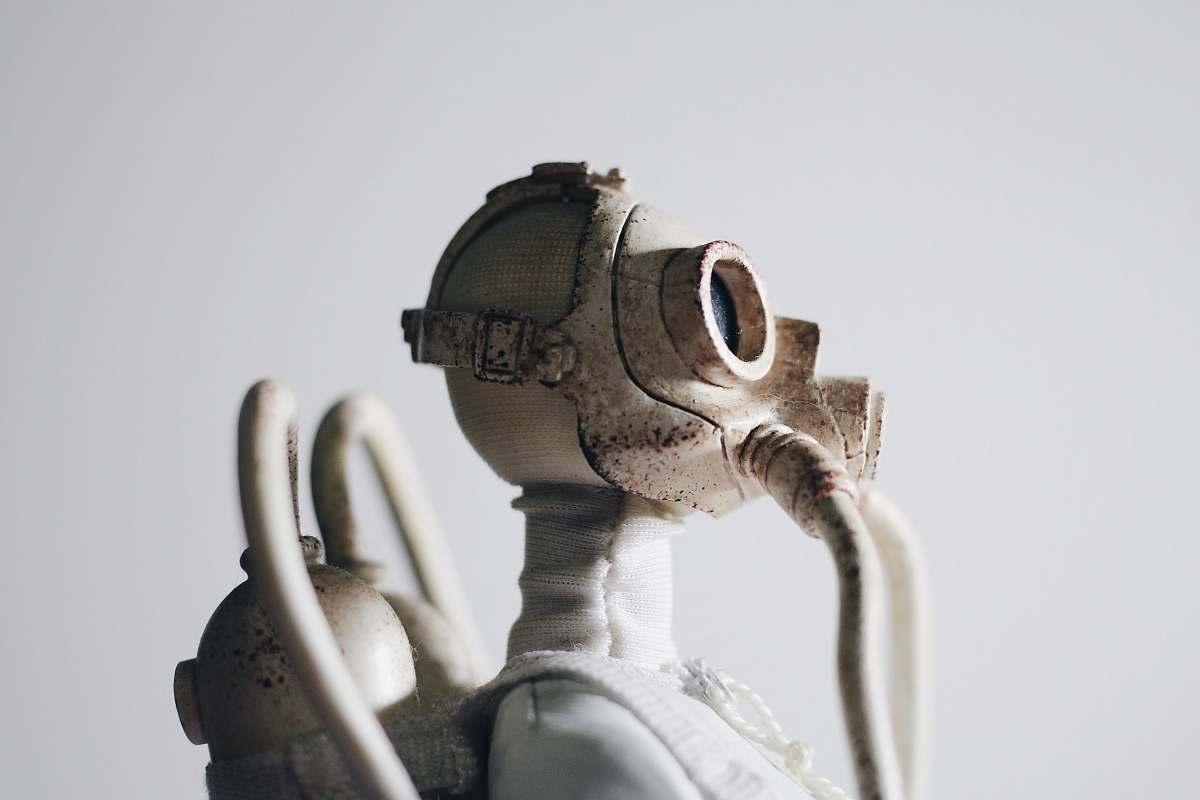 robot selective focus photography of man wearing gas mask and oxygen tank white