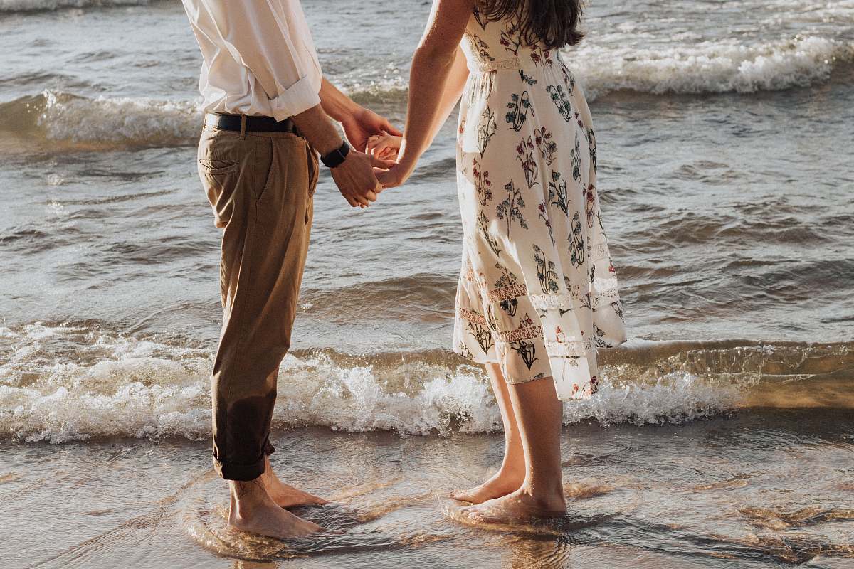 human woman holding hands in front of man standing on seashore person