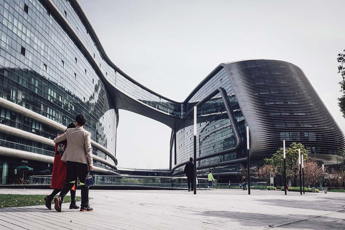 human architectural photography of glass windows of conjoined building walking