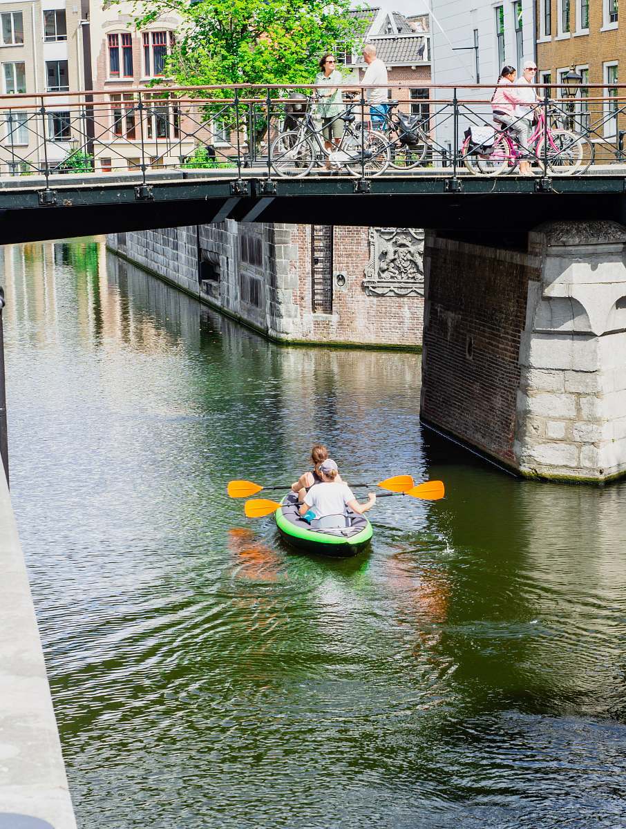 water two people kayaking under bridge boat