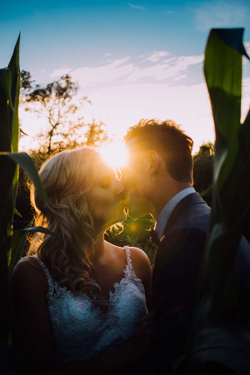 human woman and man kissing on grass field wedding