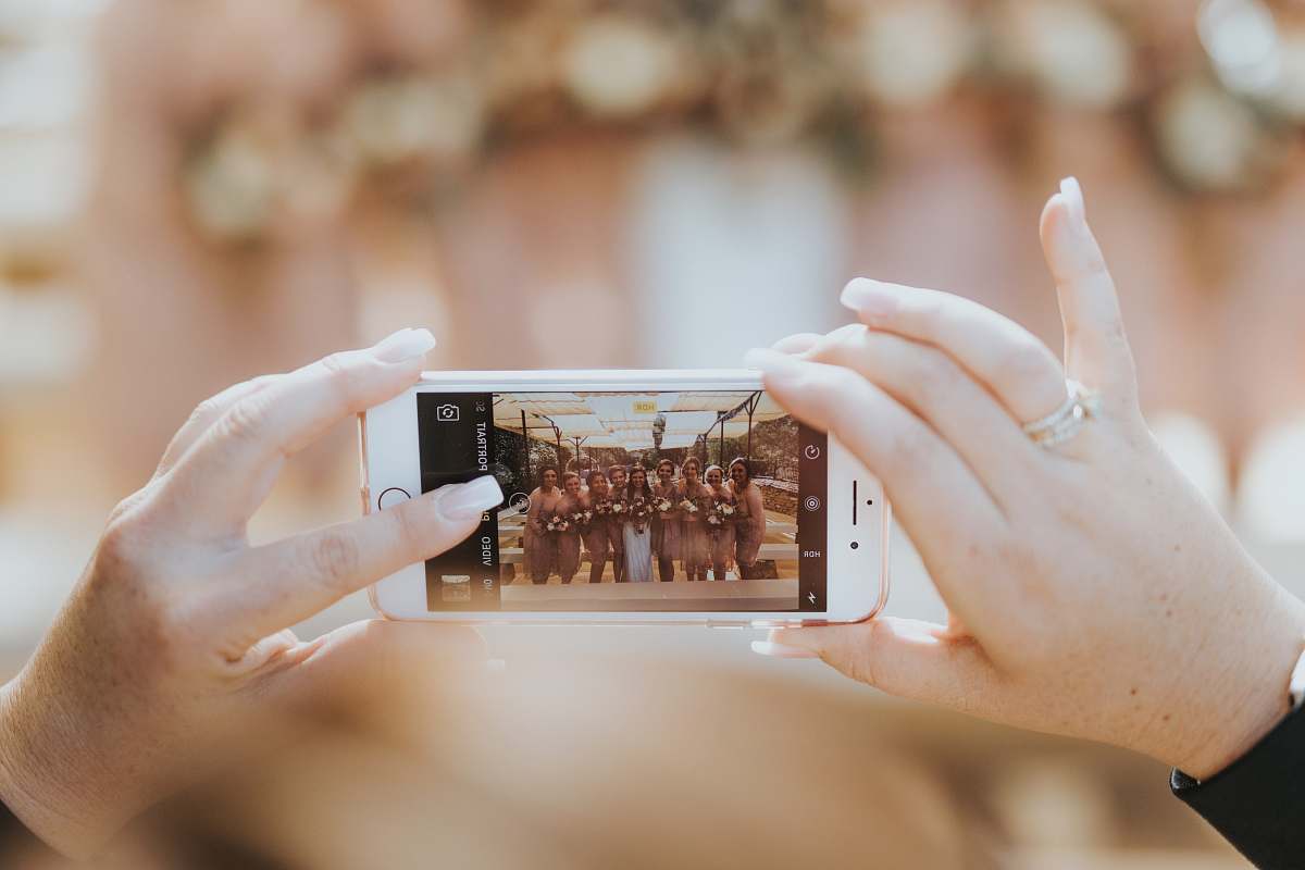 iphone person holding iPhone capturing group of women bridal party