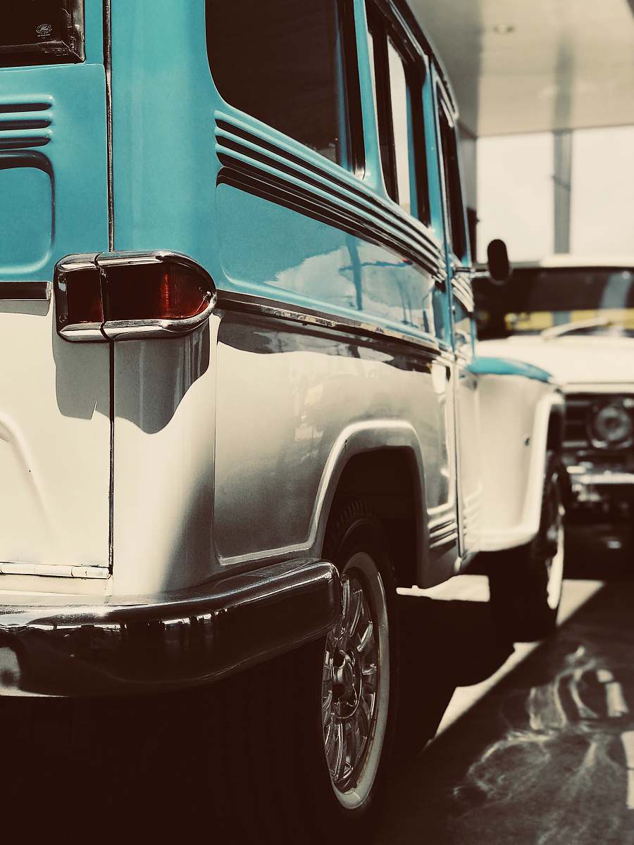 transportation white and teal vehicle parked front of white vehicle car