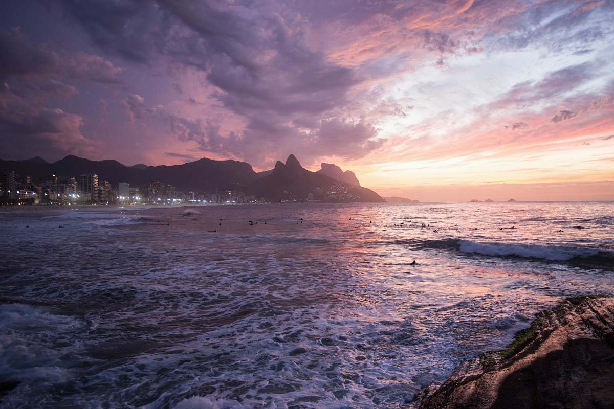backgrounds white buildings beside seashore behind mountain under thick clouds wallpapers