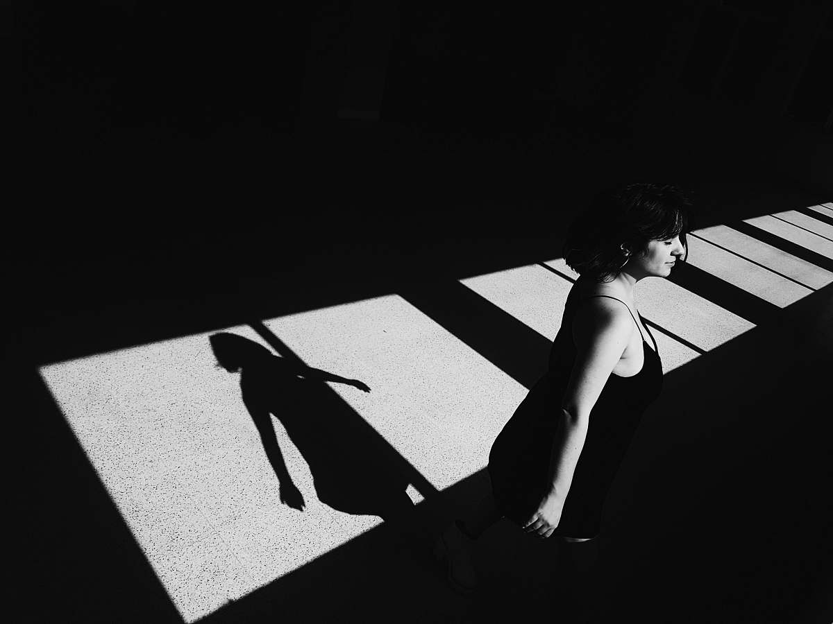 black-and-white woman standing near window grey