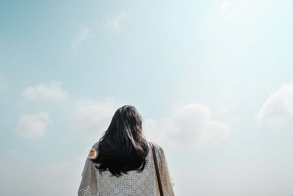back woman standing under cloudy sky during daytime blue