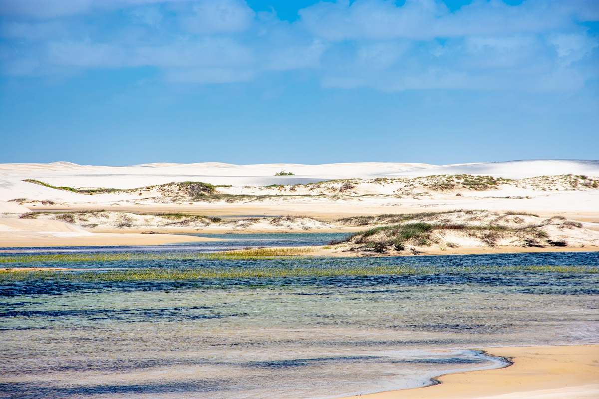 outdoors body of water near snow covered land under calm blue sky sand