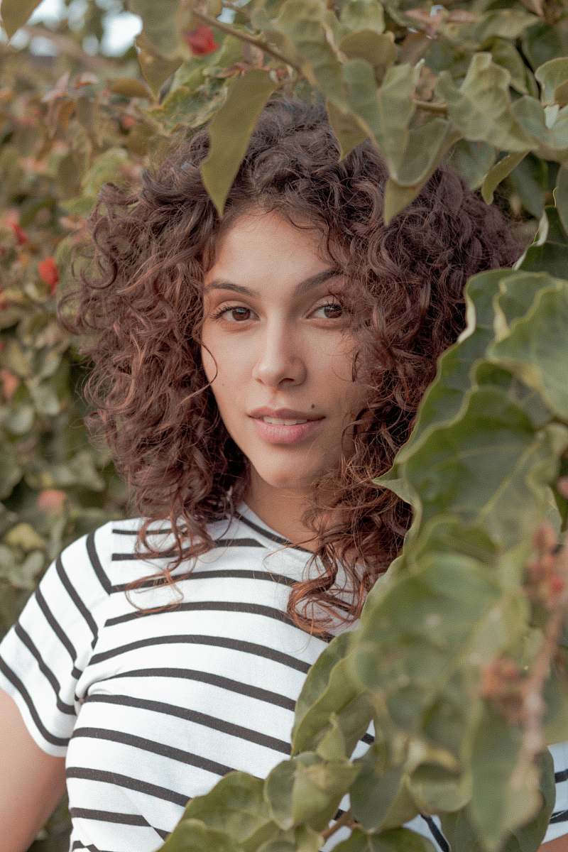 person woman standing beside green leafed plant human