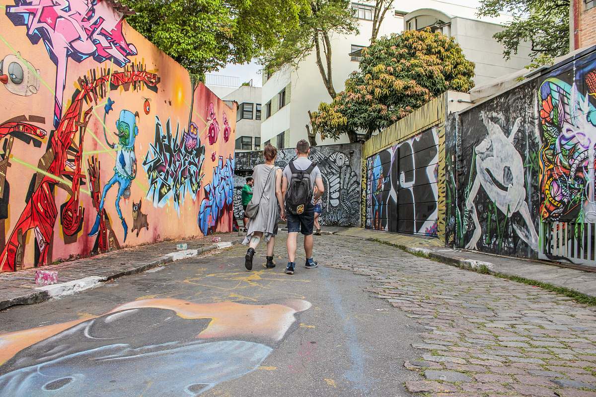 people man and woman standing between wall with graffiti artwork graffiti