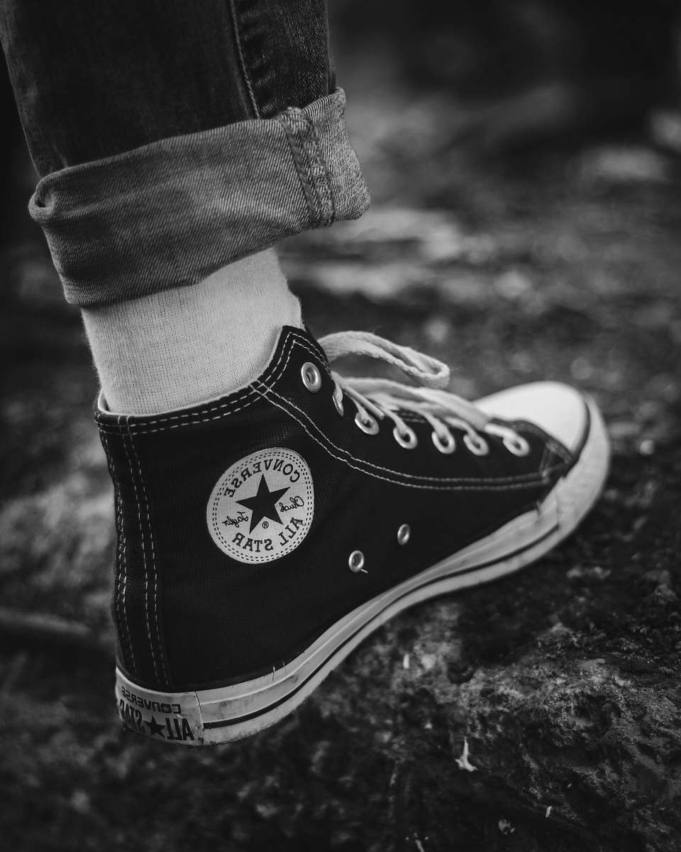 apparel grayscale photography of person in Converse high-tops clothing