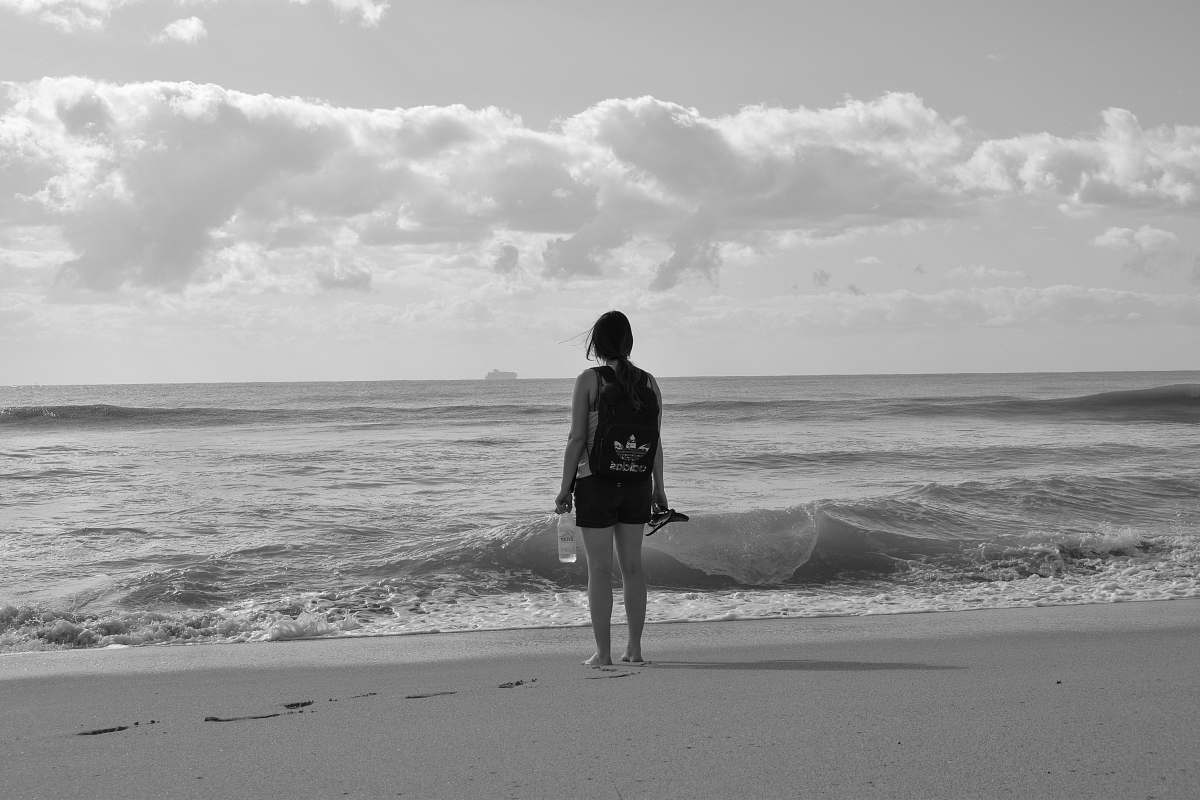 clothing woman standing near seashore facing back shorts