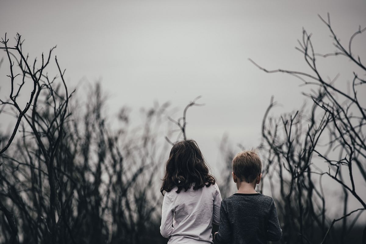 boy and girl surrounded by trees