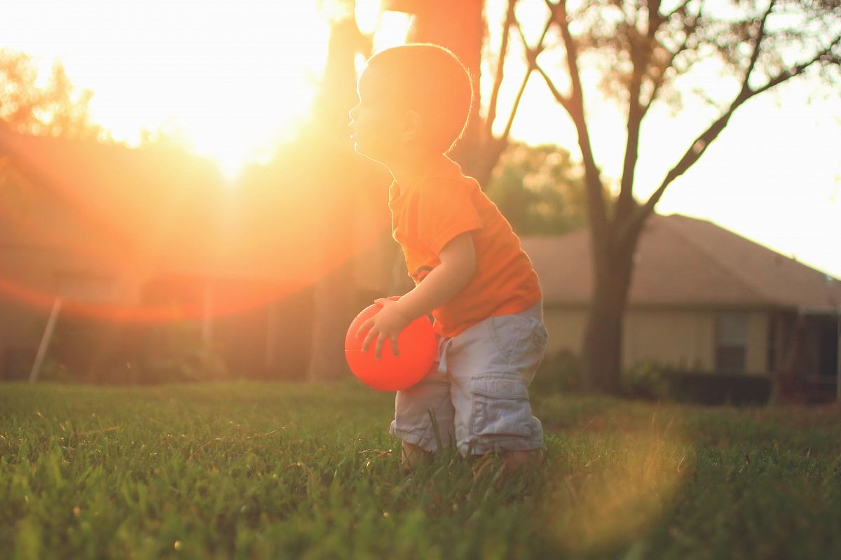 boy holding orange balloon