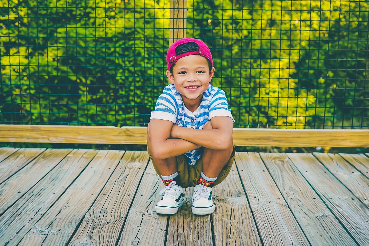 boy on wooden porch near railing