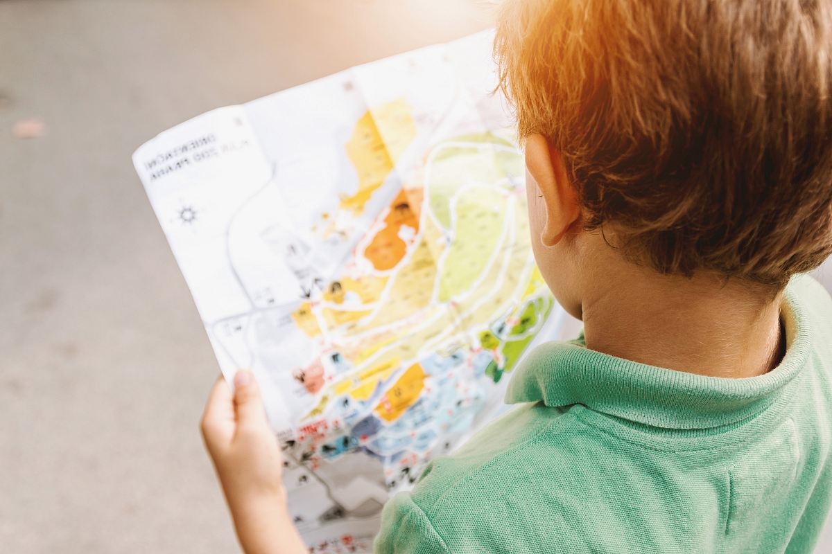 boy standing while reading map