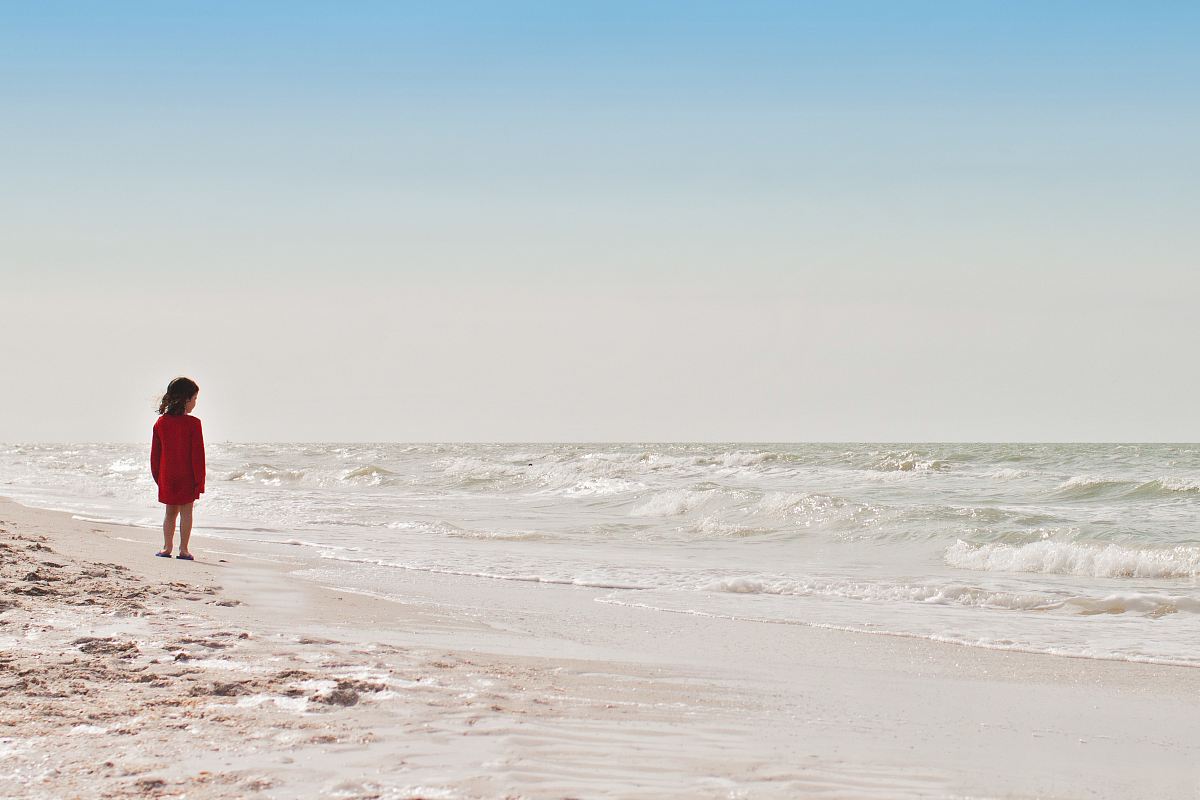 girl standing on seashore during daytime