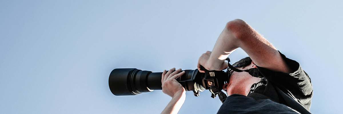 person person holding black DSLR camera people