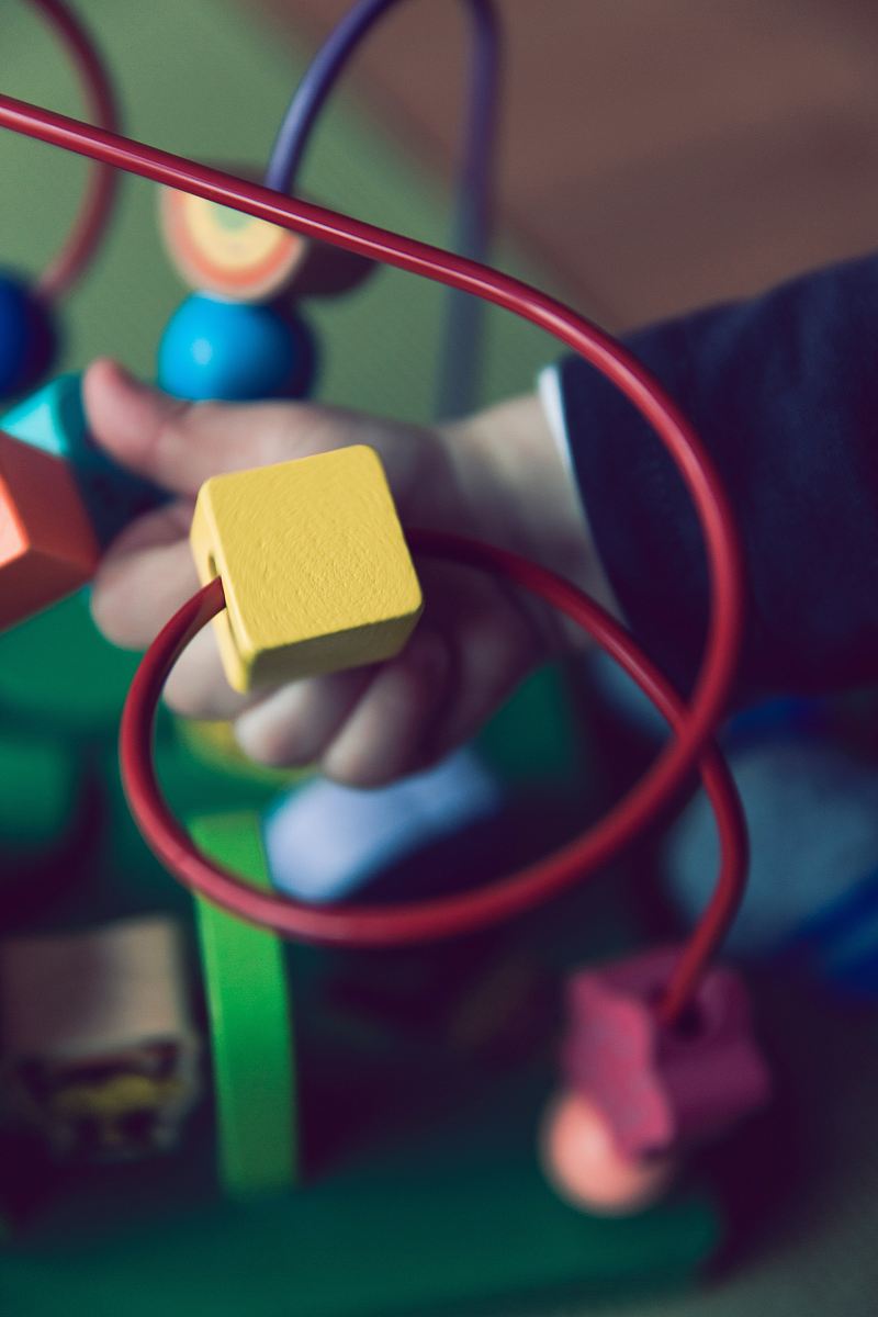 selective focus photo of baby playing activity cube