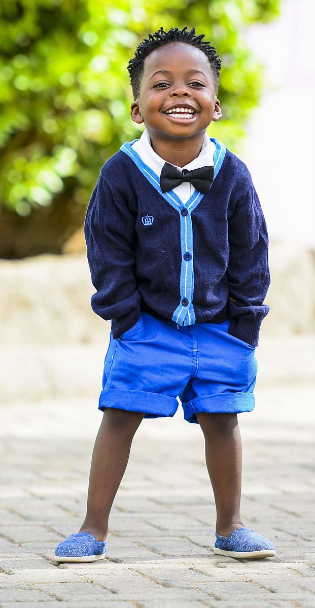 selective focus photo of boy standing on grey pavement