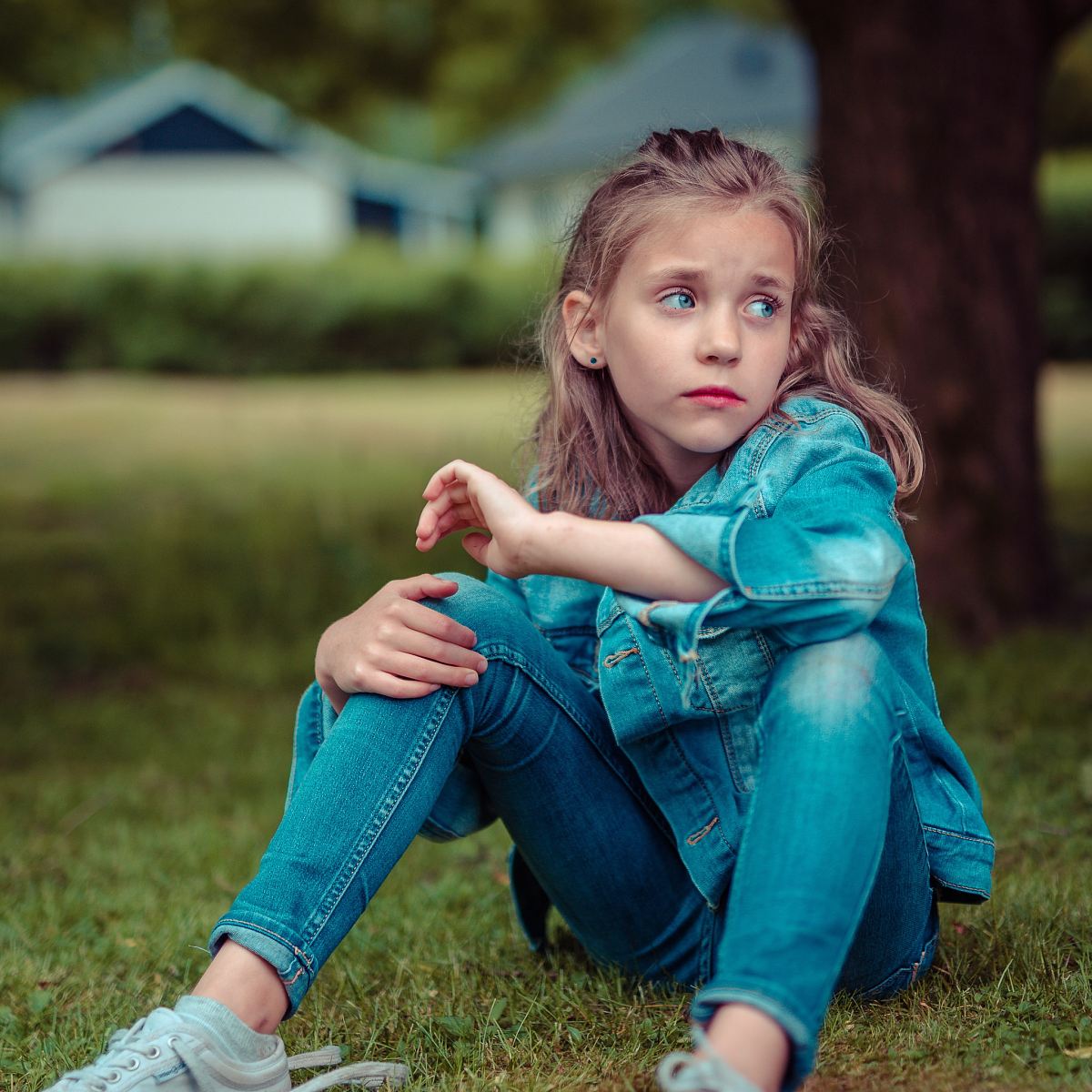 selective focus photography of girl sitting near tree