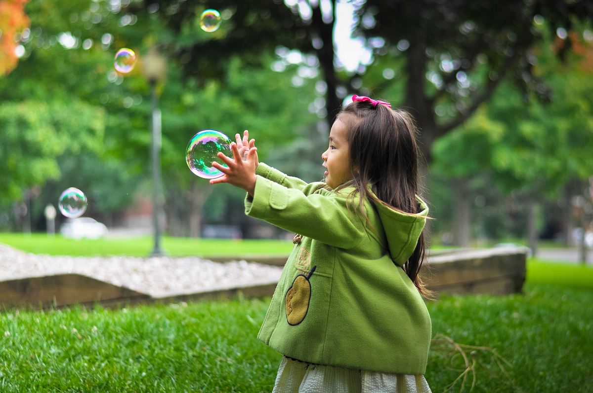 selective photo of a girl holding bubbles