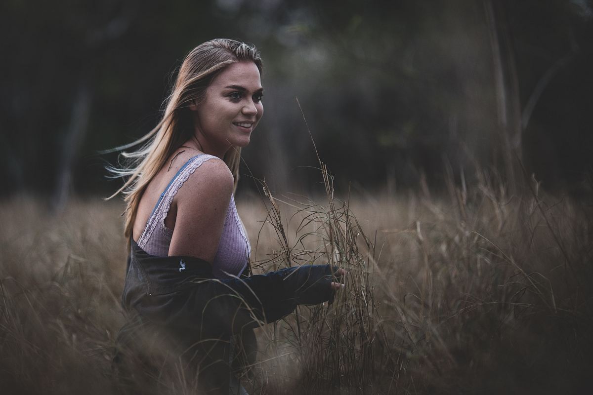 smiling woman standing on brown grass