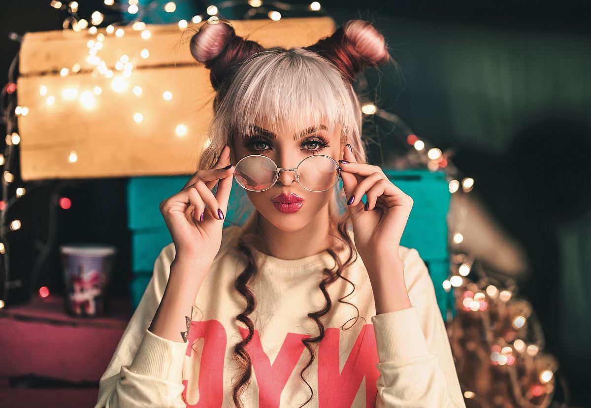 unknown celebrity holding eyeglasses under turned on lights