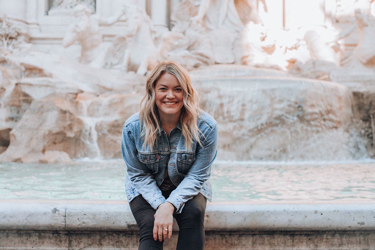 woman sitting on water fountain