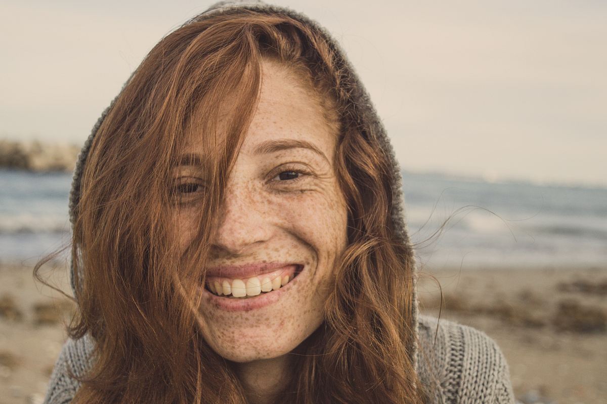 woman smiling wearing grey knit top