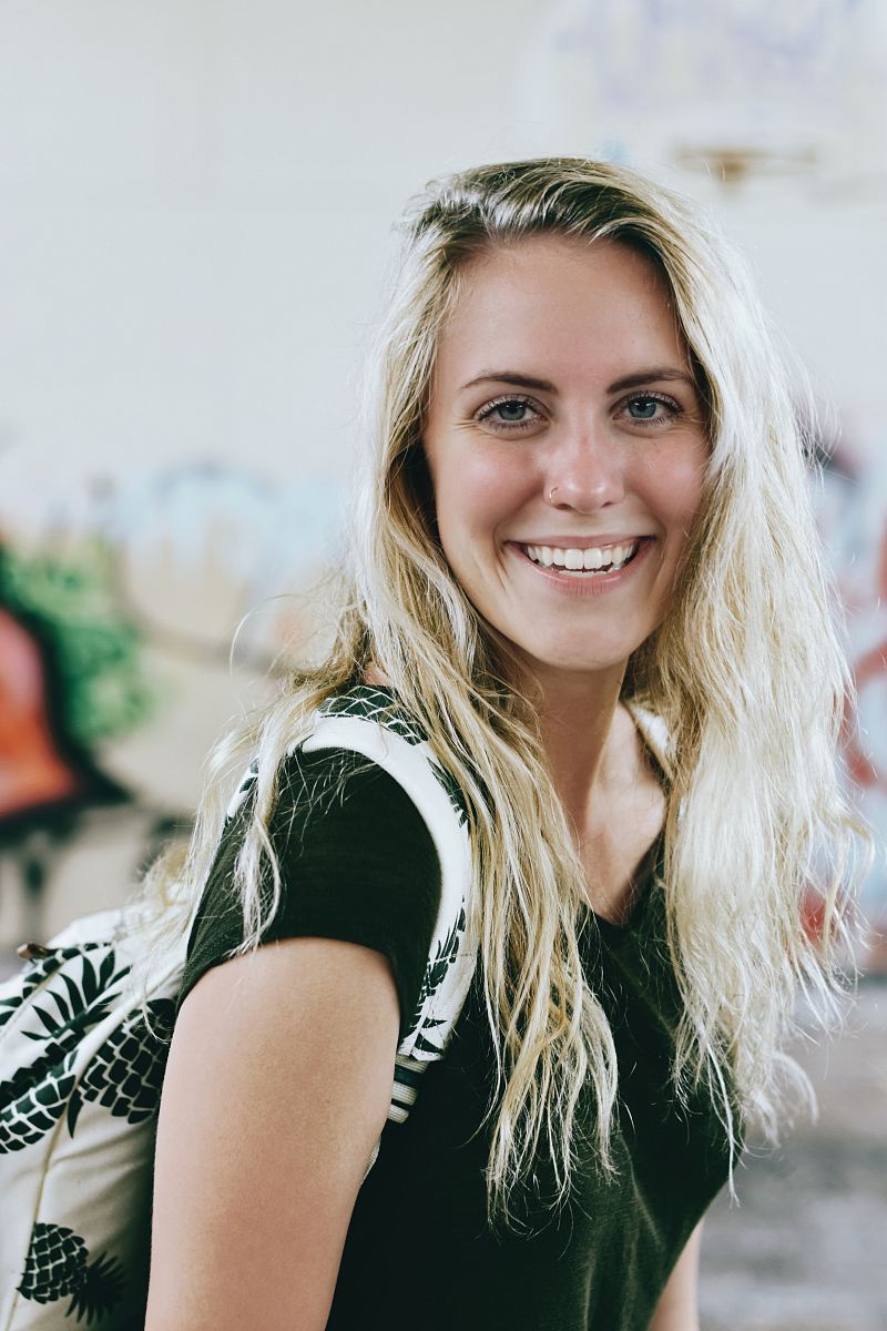 woman smiling while carrying backpack