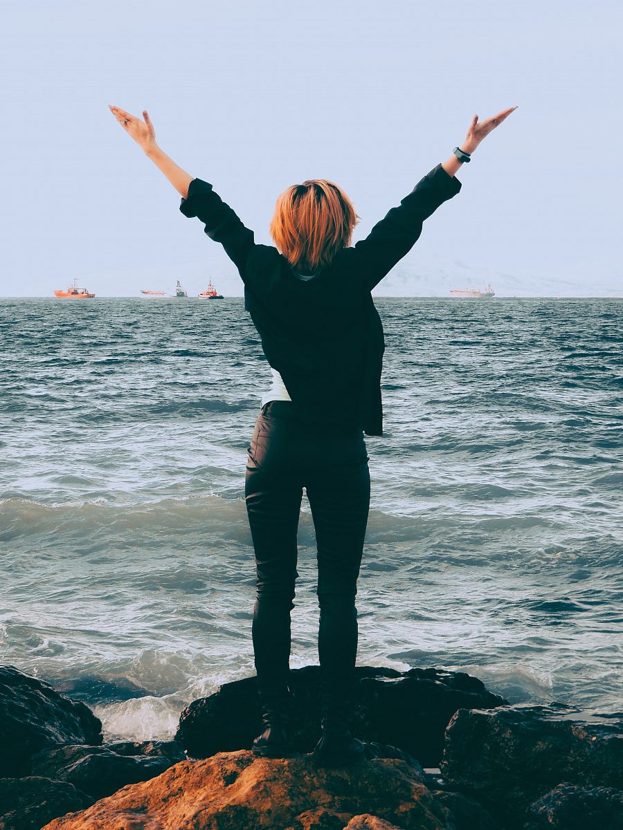 woman standing on shore near sea