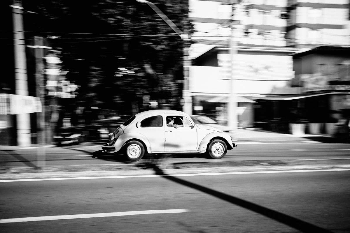 car grayscale photo of white Volkswagen Beetle car running on gray road transportation