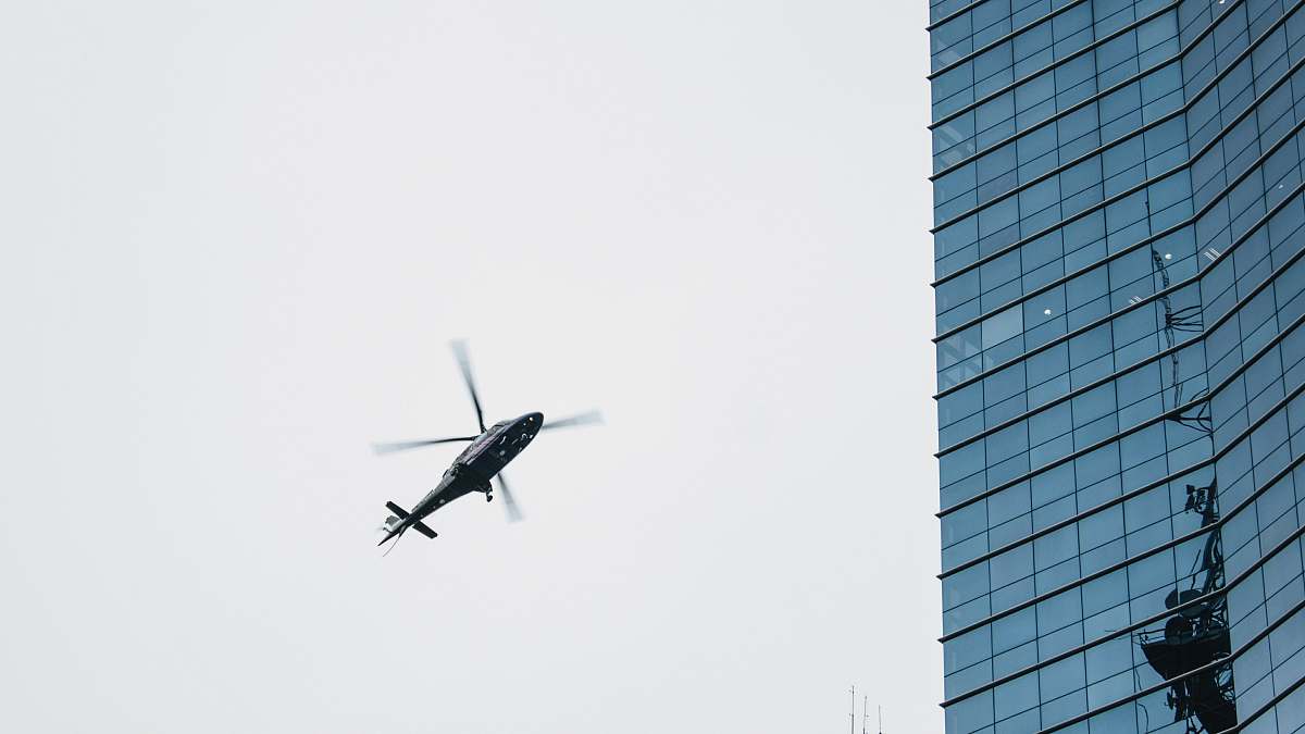 grey helicopter flying near highrise building paulista avenue