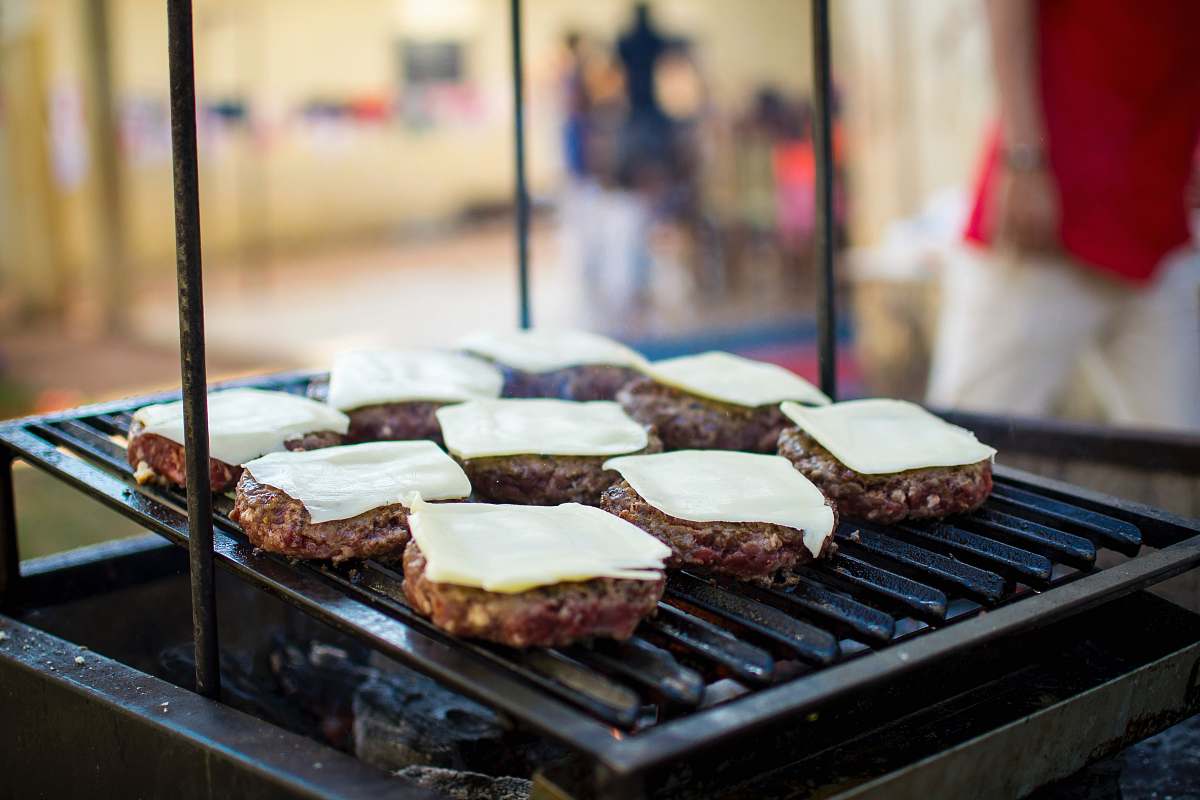 food selective focus photography of meat patty with cheese on grill bbq