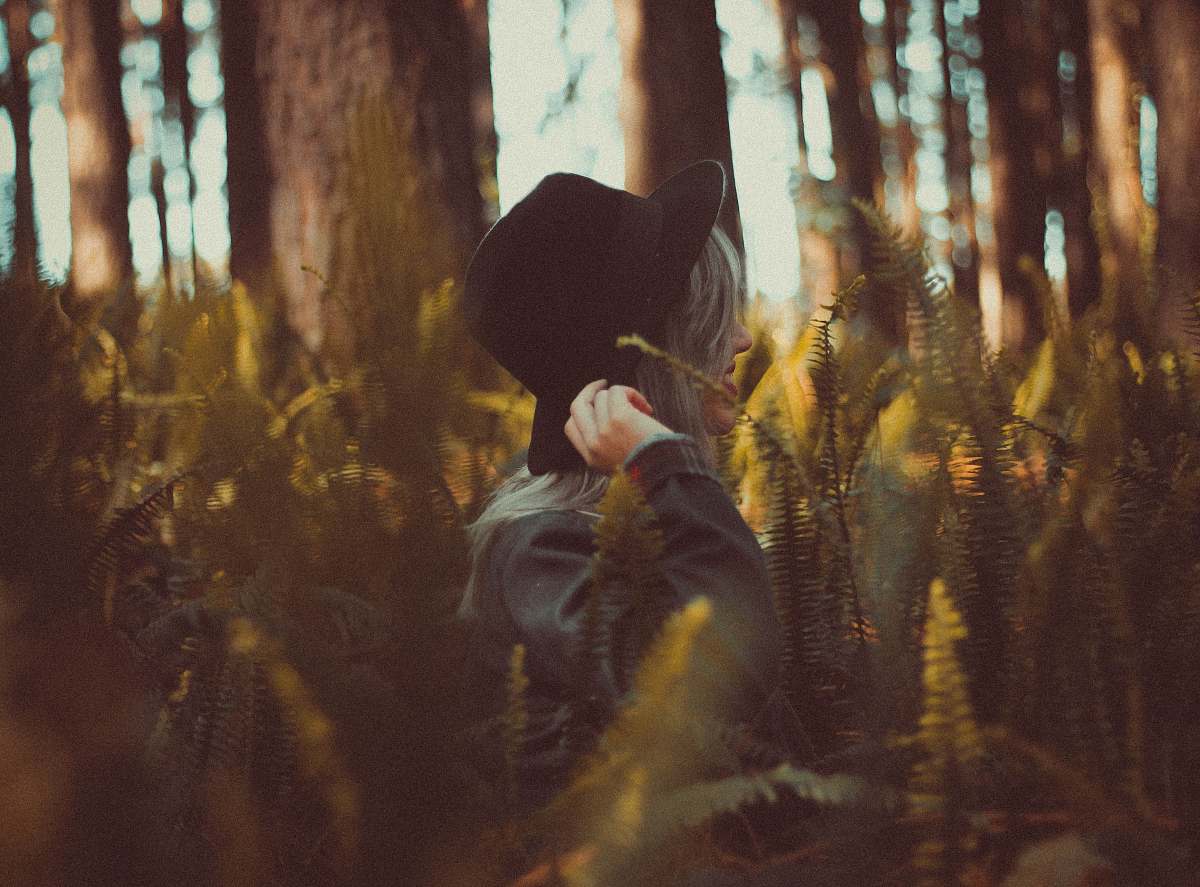 trees woman holding hat on forest at daytime girl