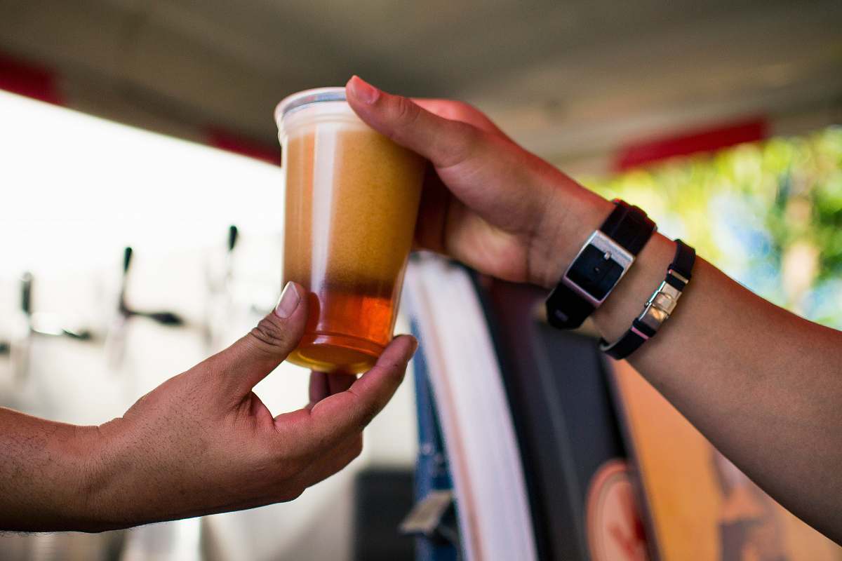 person person gives cup of beverage wristwatch