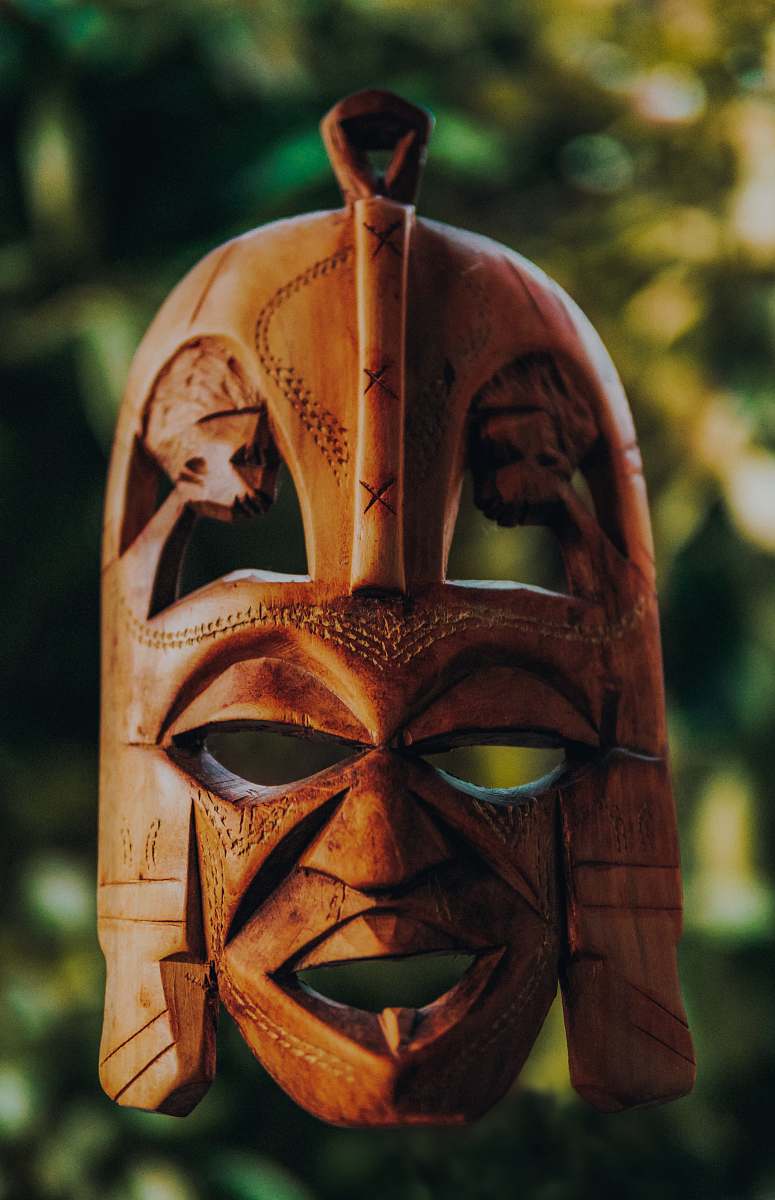 human tilt shift lens photography of brown wooden mask person