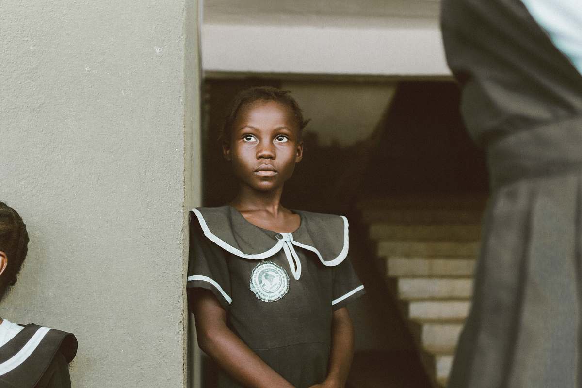 human girl leaning on white wall a liberia