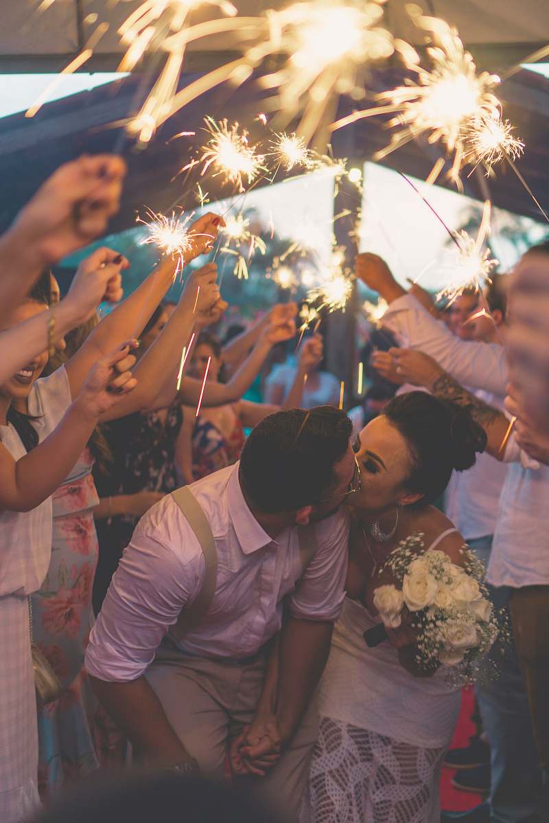 people newly wed kissing surrounded by people human