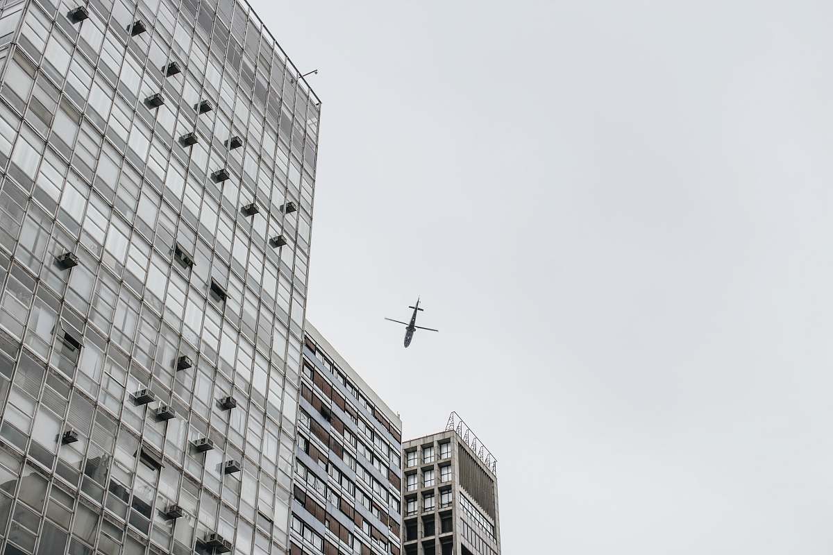 black-and-white low-angle photography of airliner and high-rise buildings grey