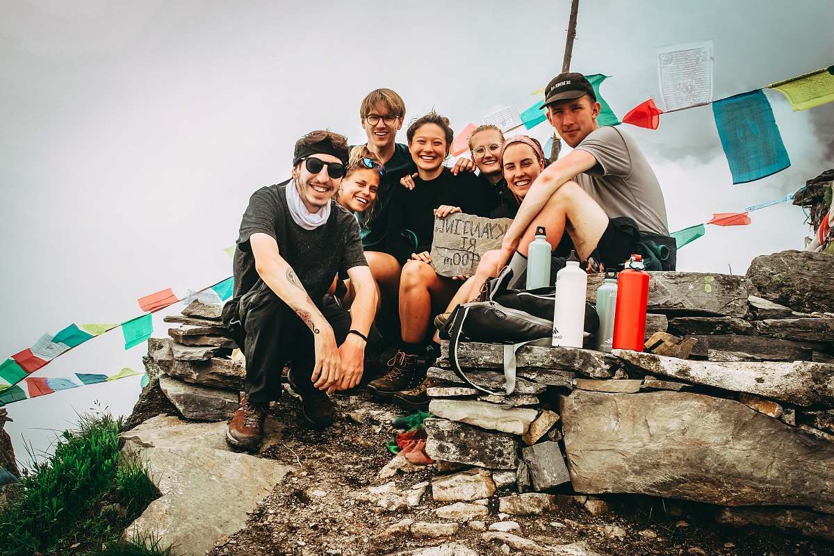 human group picture of men and women on hill at daytime person