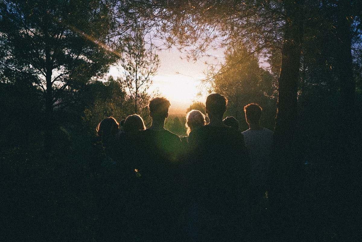 cubelles several people watching the sunrise in the middle of forest spain