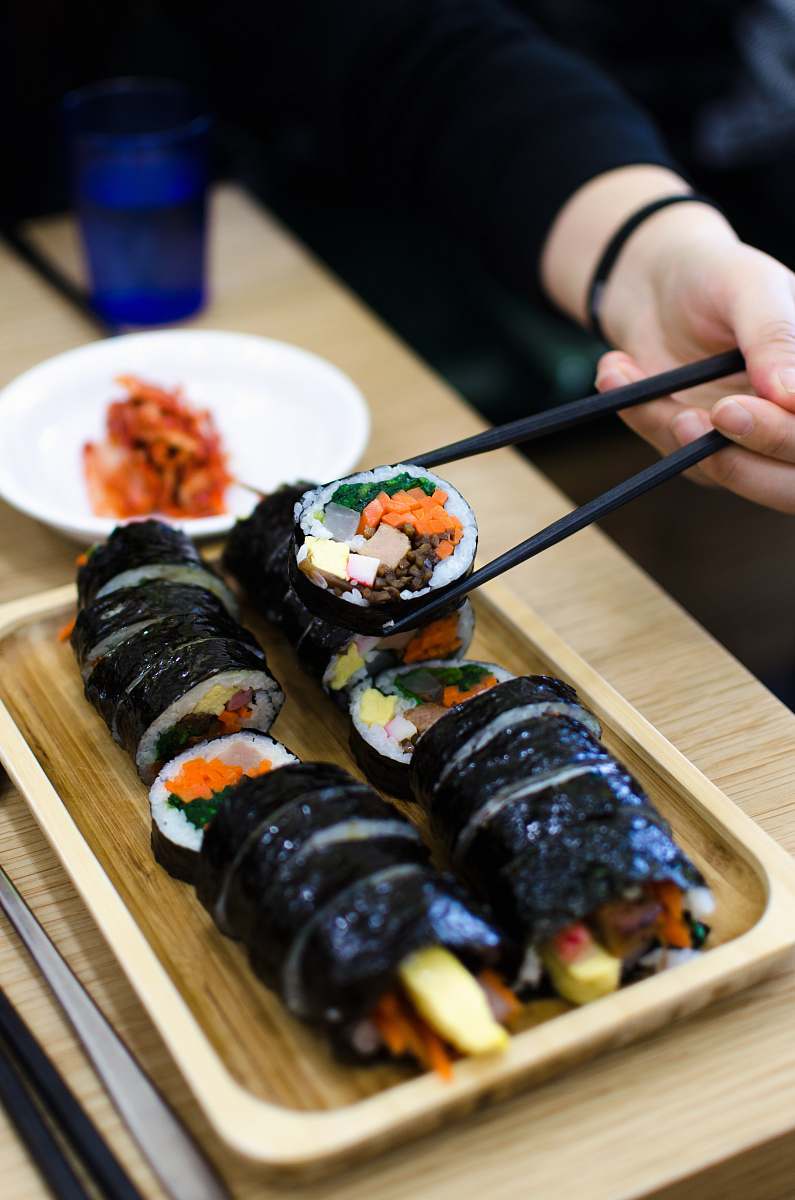 food person picking sushi using chopsticks cup