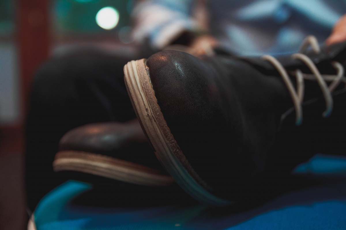 clothing person in black lace-up shoes on bed footwear