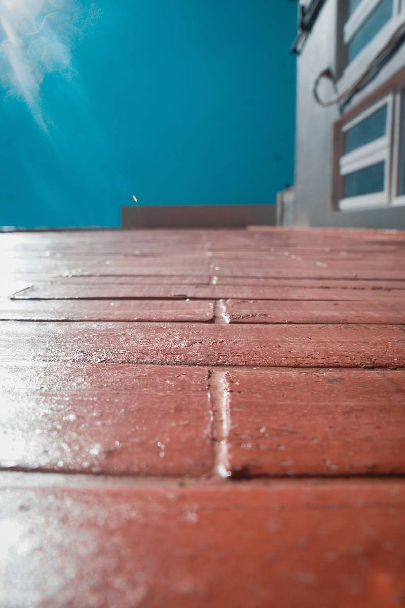 hardwood red bricked floor near blue painted wall flooring