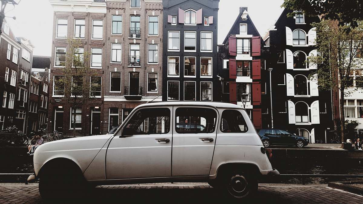 vehicle white vehicle parked beside concrete buildings transportation