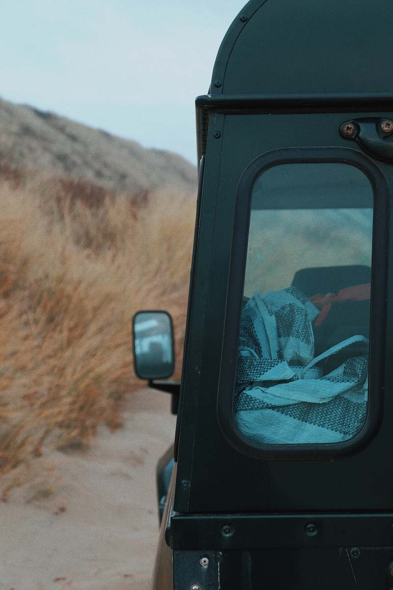 domburg closeup photo of black vehicle near dried grass camper
